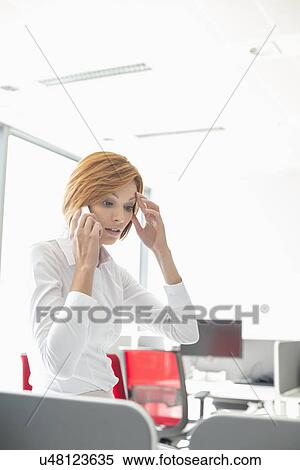 Shock businesswoman using cell phone in office View Large Photo Image Stock Photography - Shock businesswoman using cell phone in office. Fotosearch