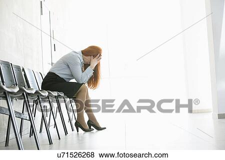 Side view of exhausted businesswoman sitting on chair in office View Large Photo Image Stock Photo - Side view of exhausted businesswoman sitting on chair in office. Fotosearch