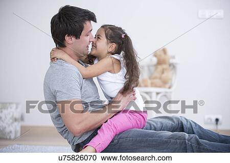 Side view of father and daughter spending quality time at home View Large Photo Image Stock Image - Side view of father and daughter spending quality time at home. Fotosearch