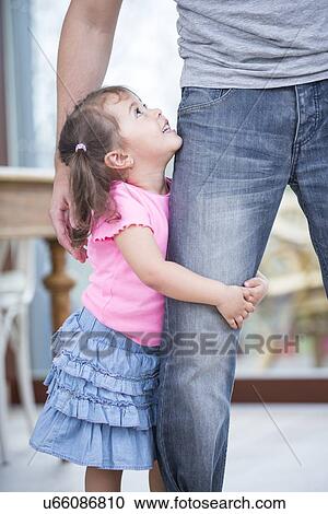 Side view of girl hugging father's leg in house View Large Photo Image Stock Image - Side view of girl hugging father's leg in house. Fotosearch