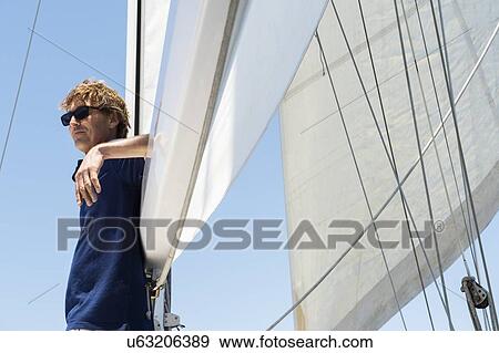 Stock Photo - Side view of middle-aged man on yacht. Fotosearch