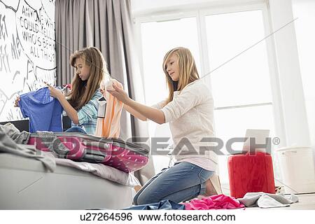Stock Photograph - Sisters cleaning bedroom. Fotosearch