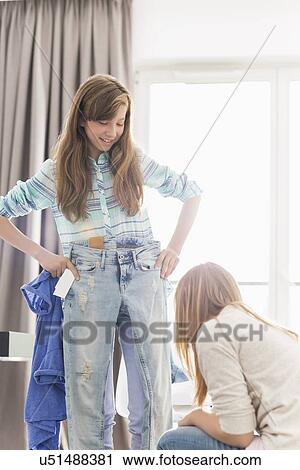 Sisters trying on clothes at home View Large Photo Image Stock Image - Sisters trying on clothes at home. Fotosearch