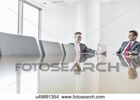 Smiling businessmen talking in conference room View Large Photo Image Picture - Smiling businessmen talking in conference room. Fotosearch