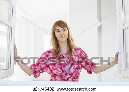 Smiling woman looking through window View Large Photo Image Stock Image - Smiling woman looking through window. Fotosearch