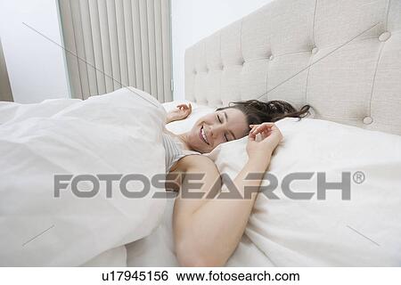 Smiling woman sleeping in bed View Large Photo Image Stock Photograph - Smiling woman sleeping in bed. Fotosearch