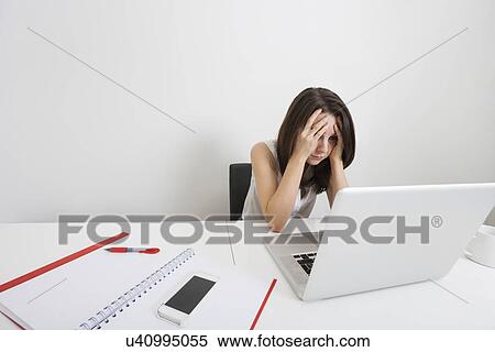 Stressed businesswoman with laptop at desk in office View Large Photo Image Stock Photography - Stressed businesswoman with laptop at desk in office. Fotosearch