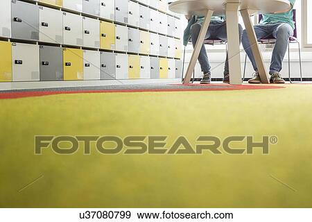 Stock Photo - Surface level of businessmen at table in creative office. Fotosearch