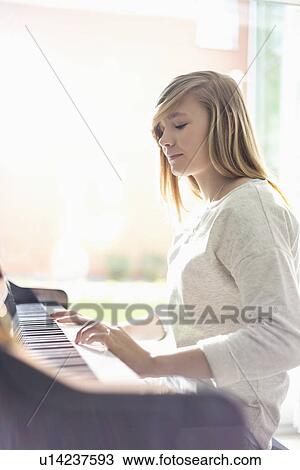 Teenage girl playing piano at home View Large Photo Image Stock Image - Teenage girl playing piano at home. Fotosearch