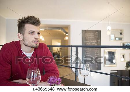 Stock Photo - Thoughtful man looking away in cafe. Fotosearch