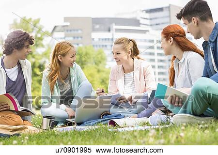 Stock Photography - University students studying together on grass. Fotosearch