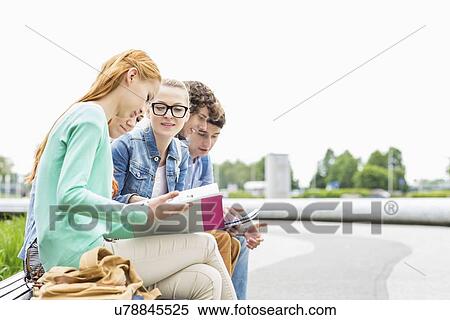 Stock Photography - University students studying together at park. Fotosearch