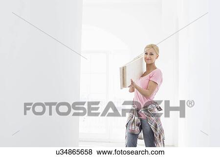 Stock Photo - Woman carrying wooden planks on shoulder. Fotosearch