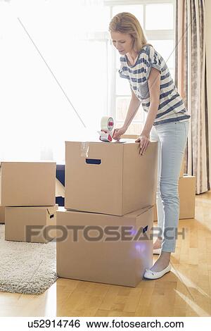 Woman packing cardboard box at home View Large Photo Image Stock Photograph - Woman packing cardboard box at home. Fotosearch