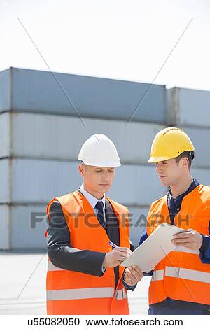 Worker taking sign of supervisor on clipboard in shipping yard View Large Photo Image Stock Image - Worker taking sign of supervisor on clipboard in shipping yard. Fotosearch