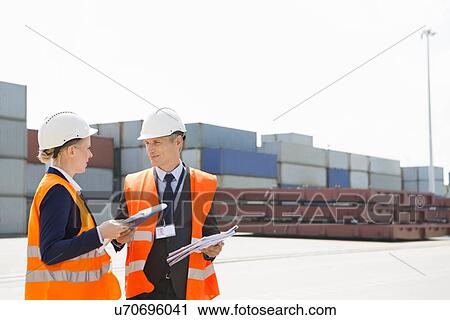 Workers discussing in shipping yard View Large Photo Image Stock Image - Workers discussing in shipping yard. Fotosearch