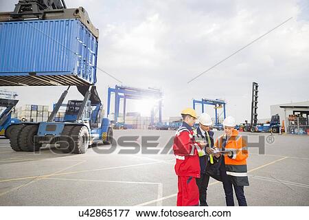 Workers discussing in shipping yard View Large Photo Image Stock Photo - Workers discussing in shipping yard. Fotosearch