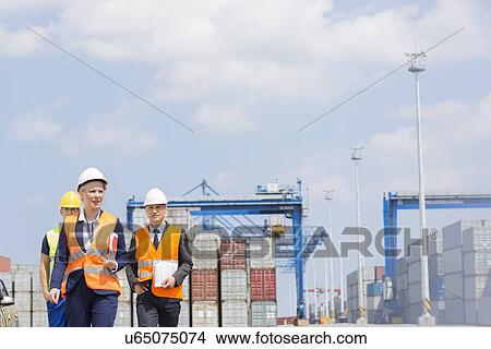 Picture - Workers walking in shipping yard. Fotosearch