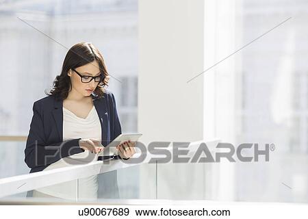 Stock Photo - Young businesswoman using tablet PC in office. Fotosearch