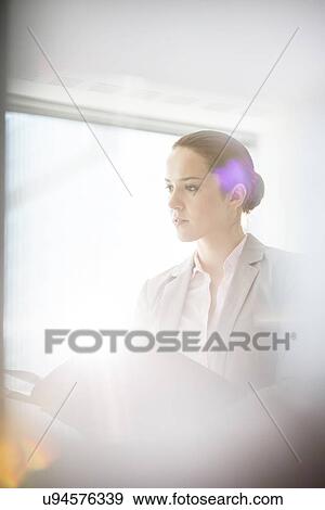 Young businesswoman with file folder in office View Large Photo Image Stock Photo - Young businesswoman with file folder in office. Fotosearch