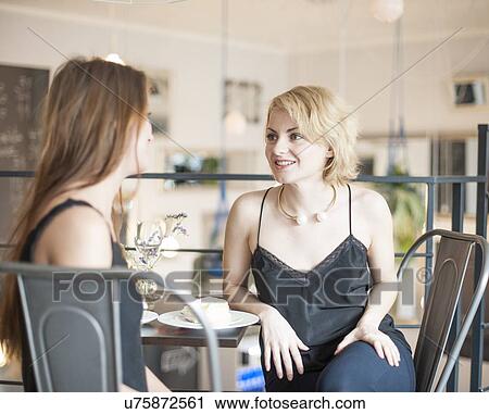 Young female friends spending leisure time at restaurant View Large Photo Image Stock Image - Young female friends spending leisure time at restaurant. Fotosearch