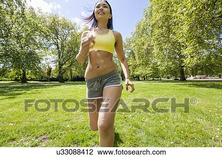 Young fit woman jogging at park View Large Photo Image Stock Image - Young fit woman jogging at park. Fotosearch