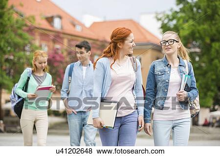 Stock Photo - Young university friends walking on street. Fotosearch