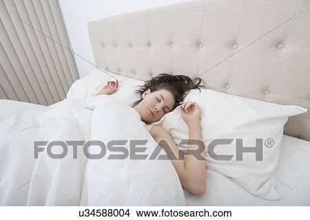 Picture - Young woman sleeping in bed. Fotosearch
