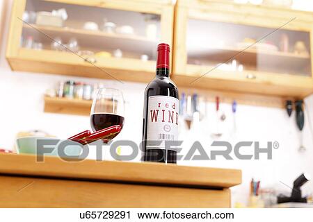 Stock Image - Bottle of red wine on a kitchen table. Fotosearch