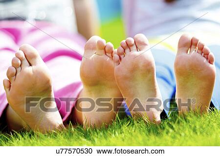 Children sitting on grass with bare feet View Large Photo Image Stock Image - Children sitting on grass with bare feet. Fotosearch