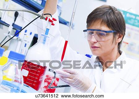 Stock Image - Female technician working in a lab. Fotosearch