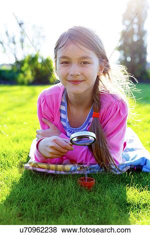 Girl with a magnifying glass and seedling View Large Photo Image Stock Photo - Girl with a magnifying glass and seedling. Fotosearch