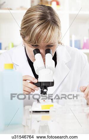 Lab technician using a microscope View Large Photo Image Picture - Lab technician using a microscope. Fotosearch