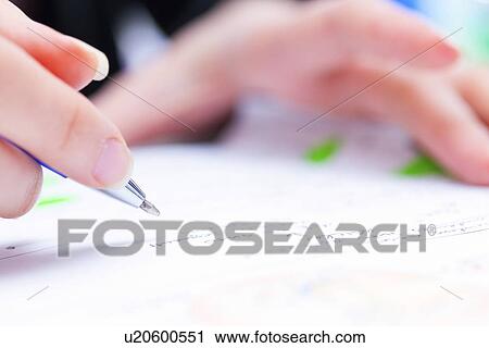 Stock Image - Person using a pen to sign a document. Fotosearch
