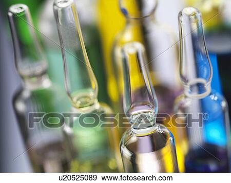 Stock Photo - A variety of drug treatments in glass bottles, close-up. Fotosearch