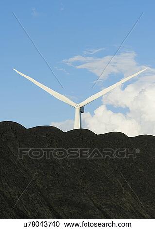 A wind turbine located behind a pile of coal, that waits to be burned in the nearby power station View Large Photo Image Stock Image - A wind turbine located behind a pile of coal, that waits to be burned in the nearby power station. Fotosearch