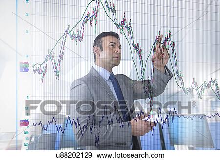 Stock Photo - Asian businessman inspecting graph on interactive display. Fotosearch