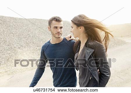 Attractive romantic young couple strolling by gravel hill View Large Photo Image Picture - Attractive romantic young couple strolling by gravel hill. Fotosearch