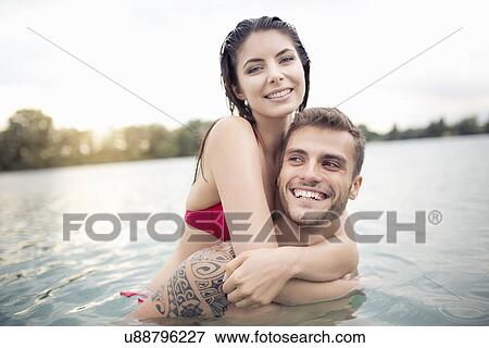 Stock Photo - Attractive young couple hugging in lake. Fotosearch