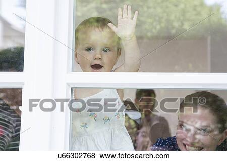 Stock Photo - Baby girl and mother looking out of window. Fotosearch