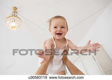 Baby girl being lifted above View Large Photo Image Stock Photo - Baby girl being lifted above. Fotosearch
