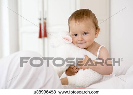 Baby girl holding soft toy View Large Photo Image Stock Photo - Baby girl holding soft toy. Fotosearch