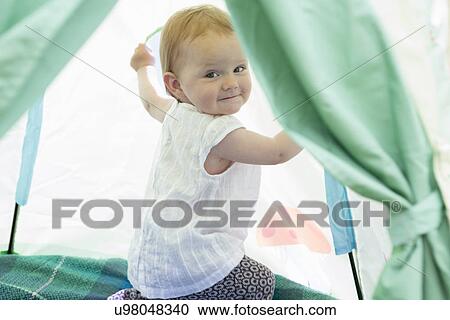 Baby girl playing in tent View Large Photo Image Stock Image - Baby girl playing in tent. Fotosearch