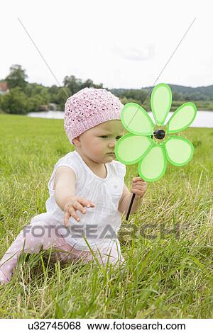 Stock Photo - Baby girl with flower shaped pinwheel. Fotosearch