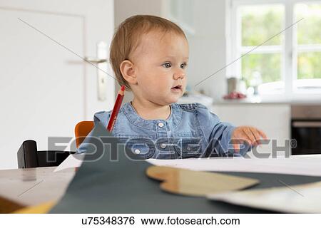 Stock Photograph - Baby girl with pencil and paper. Fotosearch