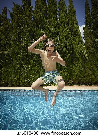 Boy jumping into swimming pool, Majorca, Spain View Large Photo Image Stock Image - Boy jumping into swimming pool, Majorca, Spain. Fotosearch