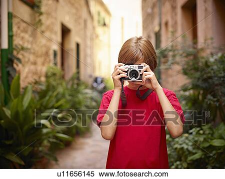 Stock Photography - Boy photographing in street using SLR camera, Majorca, Spain. Fotosearch
