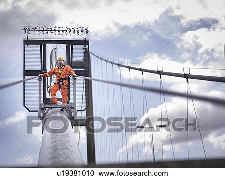 Stock Image - Bridge worker on cable of suspension bridge. The Humber Bridge, UK was built in 1981 and at the time was the world's largest single-span suspension bridge. Fotosearch