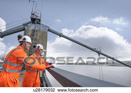 Stock Image - Bridge workers on top of suspension bridge. The Humber Bridge, UK was built in 1981 and at the time was the world's largest single-span suspension bridge. Fotosearch