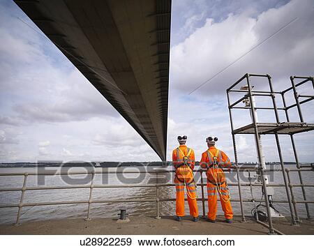 Stock Photo - Bridge workers under suspension bridge. The Humber Bridge, UK was built in 1981 and at the time was the world's largest single-span suspension bridge. Fotosearch